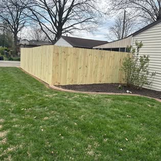 Fresh-cut lawn along a new privacy fence